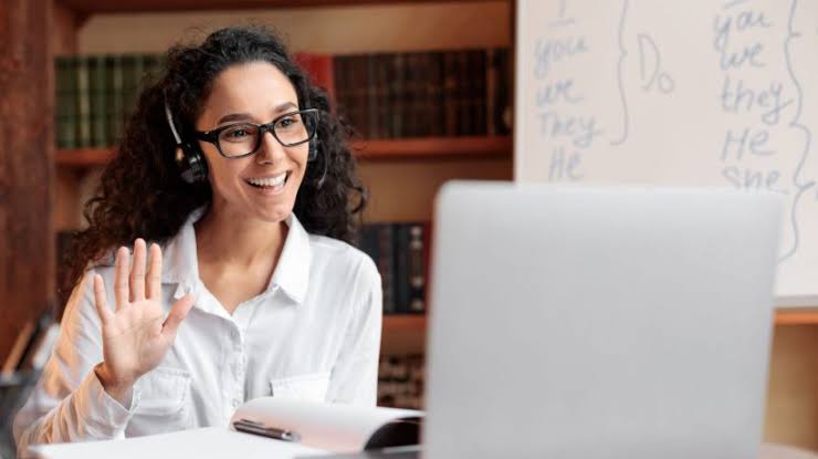 Professora dando aula de inglês online pelo computador
